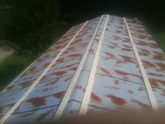 Rusted metal roof panels with new wood purlins before replacement — Storm Damage Roof Repair in Grass Lake by Roofing Brothers